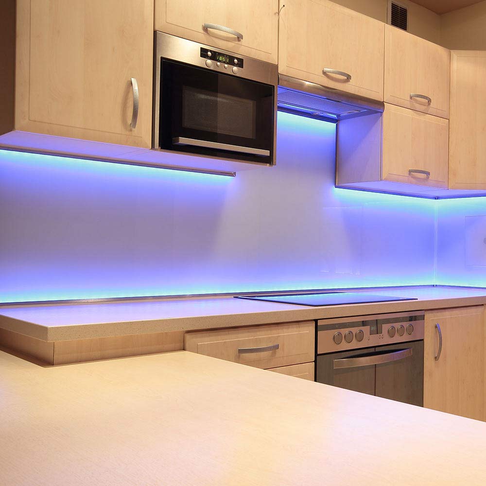آشپزخانه با کابینتهای چوبی روشن و نورپردازی LED آبی در بکاسپلش