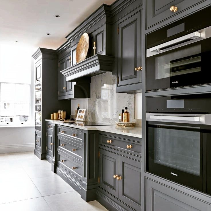 کابینت آشپزخانه کلاسیک به رنگ خاکستری تیره با دستگیرههای طلایی و لوازم توکار