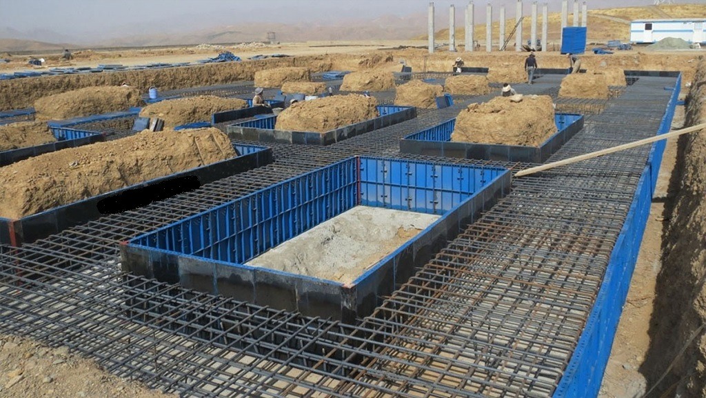 نمایی وسیع از یک سایت ساختمانی در فرانسه با قالبهای فلزی آبی رنگ برای فونداسیون