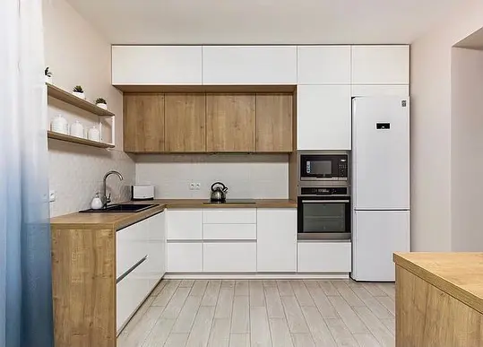 آشپزخانه مدرن با کابینتهای سفید و طرح چوب