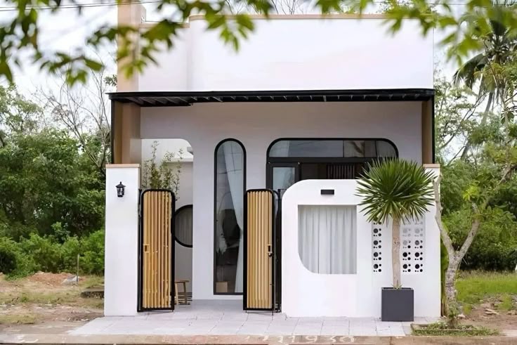 نمای بیرونی یک ویلای مدرن کوچک با خطوط منحنی، پنجره‌های قوسی، درب‌های چوبی عمودی و دیوار سفید با الگوی دایره‌ای