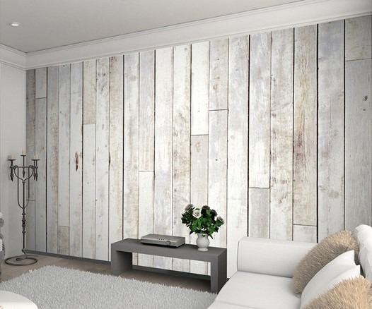کاغذ دیواری پوستری با طرح سهبعدی تختههای چوبی فرسوده (Barn Wood) به رنگ سفید و خاکستری روشن، که به صورت عمودی در یک فضای نشیمن مدرن با دکوراسیون مینیمال نصب شده است