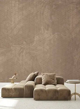 کاغذ دیواری پارچهای (Fabric Wallcovering) به رنگ بژ یا موکا (قهوهای روشن) با بافت ابروبادی و طرح هندسی مکعبهای نامنظم که بالای یک مبل مدولار مخملی به همان رنگ نصب شده است