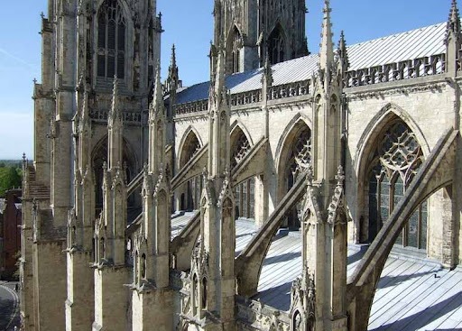 پشتبندهای معلق (Flying Buttresses) در نمای بیرونی کلیسایی به سبک معماری گوتیک، با منارههای تزئینی و قوسهای حمایتی مورب