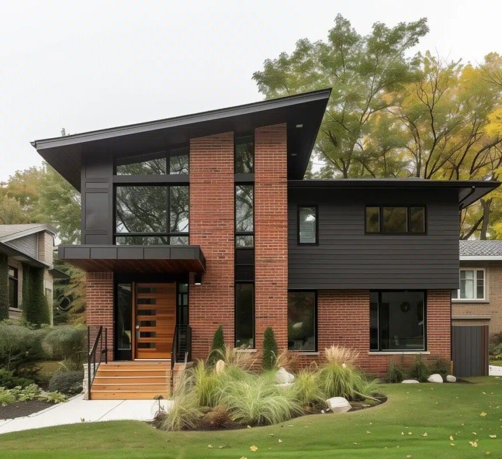 نمای مدرن یک خانه مسکونی با سقف شیب‌دار نامتقارن، ترکیب متریال آجری قرمز و پوشش تیره (شاید چوب یا فایبر سمنت)، پنجره‌های بزرگ عمودی و افقی، درب ورودی چوبی و لنداسکیپ (فضای سبز) طبیعی