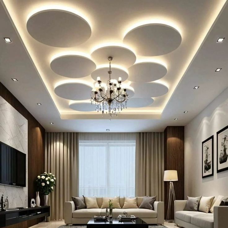 طراحی داخلی سقف پذیرایی با پنل‌های کناف دایره‌ای شناور، نور مخفی دورتادور و لوستر کلاسیک-مدرن