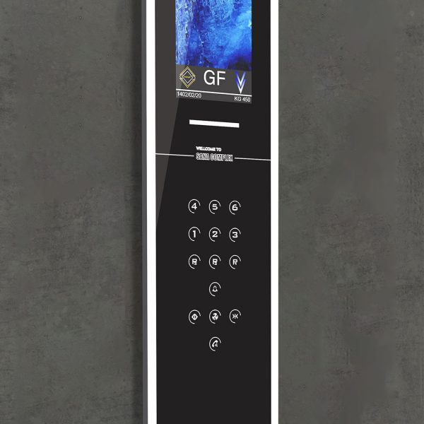 پنل فرمان عمودی و باریک آسانسور (COP) با طراحی مینیمال و رنگ مشکی براق. این پنل شامل یک نمایشگر دیجیتال در بالا برای نمایش طبقه (GF) و اطلاعات (مانند تاریخ، ظرفیت ۴۵۰ کیلوگرم و نام مجتمع 'SANA COMPLEX') است