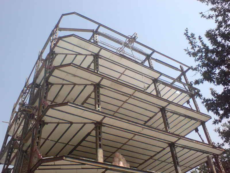 نمای بیرونی ساختمان اسکلت فلزی در حال اجرای سقف تیرچه کرومیت با بلوکهای فومی جهت بتنریزی