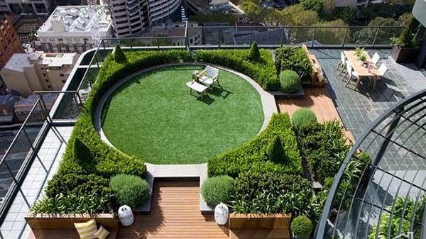 طراحی بام سبز لوکس و مدرن (روف گاردن) بر روی سقف یک ساختمان بلندمرتبه شهری با فضای نشیمن و چمن مصنوعی دایرهای