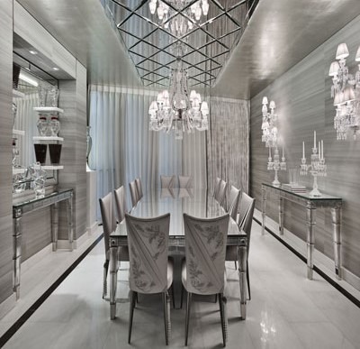 سقف آینه‌ای یا سقف کشسان بسیار براق با طرح هندسی و لوستر کریستالی در فضای غذاخوری مجلل با تم نقره‌ای