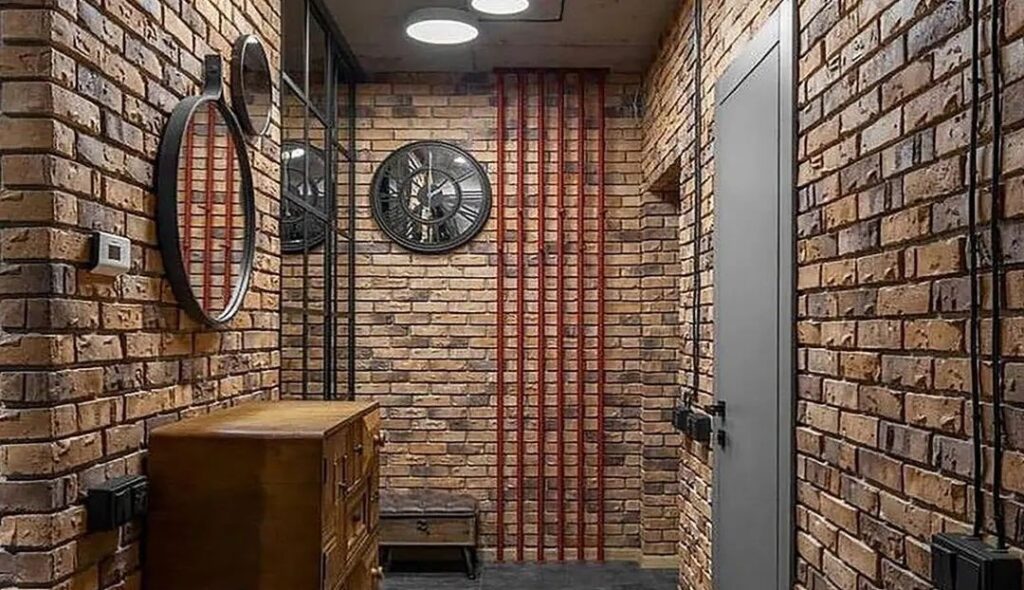 دکوراسیون داخلی به سبک صنعتی با آجر رستیک قهوه‌ای، ستون فلزی، آینه‌های گرد و سیم‌کشی روکار مشکی
